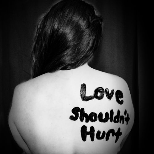 love shouldn't hurt-printed on back of woman